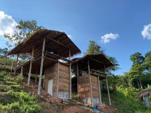 Ban Huai Tiสะปันซีวิว ที่พักบ้านสะปัน บ่อเกลือ น่าน的山丘上一座茅草屋顶的建筑