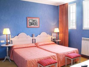 纳瓦雷特圣卡米洛酒店的一间卧室设有两张床,拥有蓝色的墙壁。