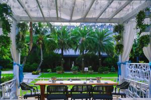 三亚三亚丽禾温德姆酒店(首日迷你吧+接或送机)的棕榈树亭子中的桌椅