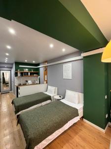 阿拉木图Evergreen Apart的一间设有三张床和绿色墙壁的客房