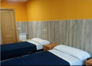 瓜达拉哈拉圣马科斯2号旅馆的黄色墙壁客房的两张床