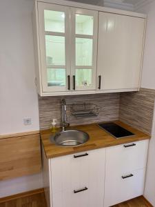 木洛希尼Studio Lorena的白色的厨房设有水槽和2扇窗户