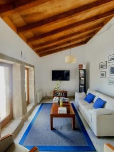 MiñortosCasa do Fieiro的客厅设有白色沙发和木制天花板
