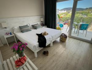 马盖鲁夫INN Mallorca Aparthotel的一间带白色床的卧室和一个阳台