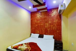 坎普尔Goroomgo Atithi Galaxy Kanpur Near Railway Station - Hotel-at-Prime-Location Spacious-Room with-wi-fi & Parking Availability,的卧室配有一张带聚光灯的墙壁床。