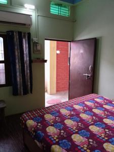 瓦拉纳西ASHA paying guest house的一间卧室配有一张床,一扇门通往一个房间