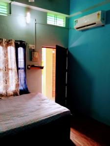 瓦拉纳西ASHA paying guest house的一间设有床铺和蓝色墙壁的客房