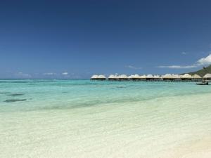 MaharepaSofitel Kia Ora Moorea Beach Resort的海滩上,有一把遮阳伞和大海