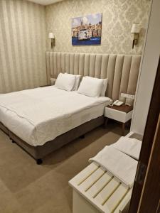 伊斯坦布尔Mr BEYAZ HOTEL的一间卧室配有一张带白色床单的大床