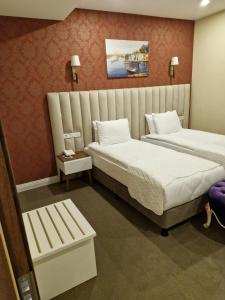 伊斯坦布尔Mr BEYAZ HOTEL的酒店客房带两张床和长凳