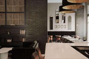 萨凡纳萨凡纳历史区江山旅馆&套房酒店的一间设有白色桌椅的餐厅,拥有砖墙
