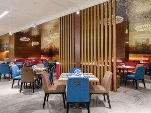 花都Novotel Guangzhou Baiyun Airport的一间配备有桌子和蓝色椅子的用餐室