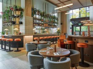 伦敦TRIBE London Canary Wharf的一间带桌椅的餐厅和一间酒吧