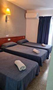 埃尔阿雷纳尔SB Arenal的配有蓝色床单的客房内的三张床