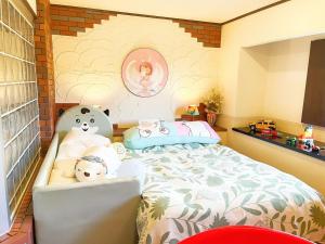 涩川市Ikaho Kids Paradise Hotel - Vacation STAY 56072v的一间卧室,配有一张带两个泰迪熊的床