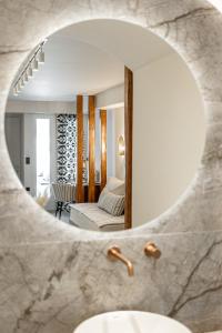 布拉卡Nikos & Maria Apts - Suites的一个带盥洗盆的浴室镜子和一间客厅