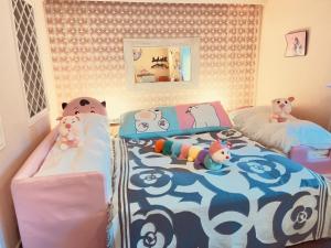 涩川市Ikaho Kids Paradise Hotel - Vacation STAY 56430v的一间卧室设有两张床,里面装有动物