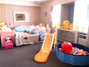 涩川市Ikaho Kids Paradise Hotel - Vacation STAY 56430v的儿童卧室设有两张床和一个游乐区