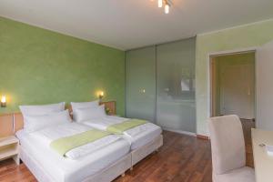 比勒费尔德布兰德布希瓦尔德酒店的卧室配有白色的床和绿色的墙壁