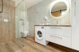 济夫努夫Dom Gościnny Amber Dziwnów - apartamenty i pokoje的一间带洗衣机和镜子的浴室