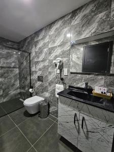 凯里尼亚Suya Boutique的一间带卫生间和水槽的浴室以及一台电视。