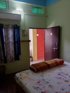 瓦拉纳西ASHA paying guest house的一间卧室配有一张床,浴室设有门
