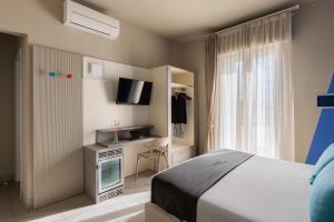 毕博纳的码头尼娜酒店的一间卧室配有一张床和一张书桌及电视