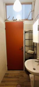 维贾内洛Tana Libera Tutti 1 Nature, Yourself, Love的一间带红色门和水槽的浴室