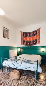 维贾内洛Tana Libera Tutti 1 Nature, Yourself, Love的一间卧室配有一张带绿色床头板的床