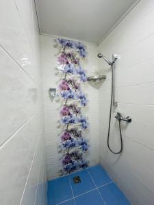 切尔诺夫策Студія біля резиденції університету的墙上设有带鲜花淋浴的浴室