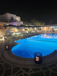 纳乌萨Zoumis Residence的夜间蓝色海水的大型游泳池