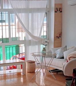 卡拉德莫尔Playa Beach Malaga 3habts dobles, cocina familiar, apartamento completo的带沙发和玻璃桌的客厅