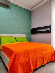 那不勒斯Gians B&B的一间卧室配有带绿色枕头的橙色床