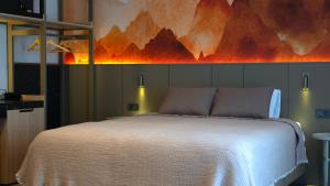 阿拉尼亚克列奥帕特拉德里姆斯海滩酒店的卧室配有一张白色床,墙上挂有绘画作品