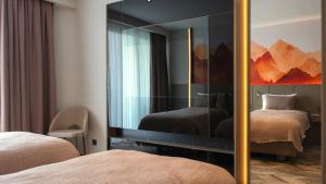 阿拉尼亚克列奥帕特拉德里姆斯海滩酒店的一间设有两张床和大镜子的房间