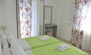 拉卡Konstantina Apartment的一间卧室配有绿色的床和镜子