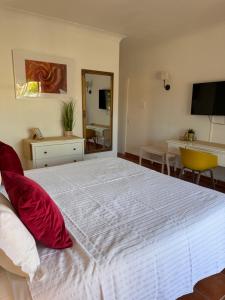 拉戈斯Vila Graciosa - Tranquility Oasis的卧室配有带红色枕头的大型白色床
