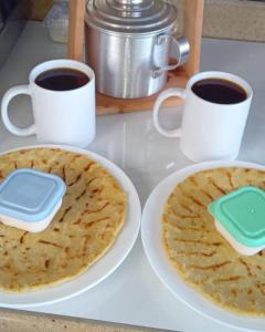 迦太基Glamping La Mardo的盘子上的两个煎饼和两杯咖啡