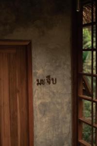 清迈Woo Ma Ca Moo的门旁墙上的标志