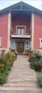 苏安塞斯Alojamientos Marte casa rural的粉红色的建筑,有通往门的走道