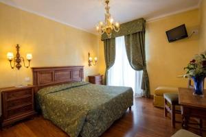 威尼斯丽都瑞吉尔酒店的一间卧室配有一张床和一个吊灯