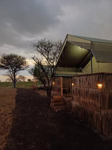 巴纳吉Green Garden Serengeti Luxury Tented Camp的田间中带帐篷的建筑