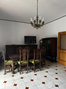 MutignanoLa Foresteria- Azienda agricola Garra的一间带桌椅和吊灯的用餐室