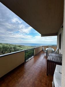 MutignanoLa Foresteria- Azienda agricola Garra的阳台配有桌椅,享有海景。