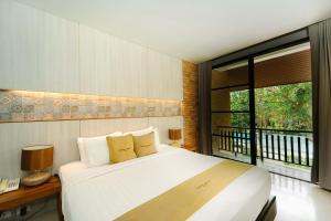 素可泰Sukhothai Treasure Resort & Spa- SHA Plus Certified的一间卧室设有一张大床和一个窗户。