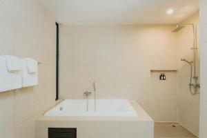 素可泰Sukhothai Treasure Resort & Spa- SHA Plus Certified的白色的浴室设有浴缸和淋浴。