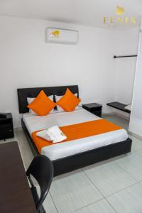 库库塔Hotel Fenix的一间卧室配有带橙色枕头和椅子的床
