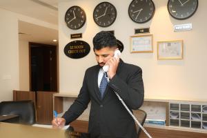 麦纳麦Noor Amwaj Hotel & Apartment的电话交谈时,一个男人在电话上说话
