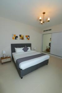麦纳麦Noor Amwaj Hotel & Apartment的一间卧室配有大床和投影屏幕