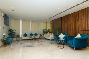 麦纳麦Noor Amwaj Hotel & Apartment的大楼内带蓝色桌椅的大堂